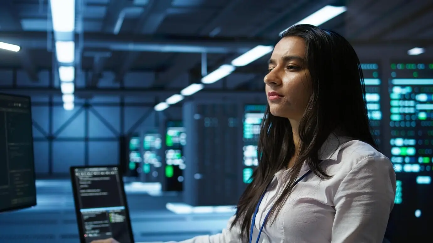Информатик в дата-центре осуществляет мониторинг угроз безопасности с помощью компьютера.