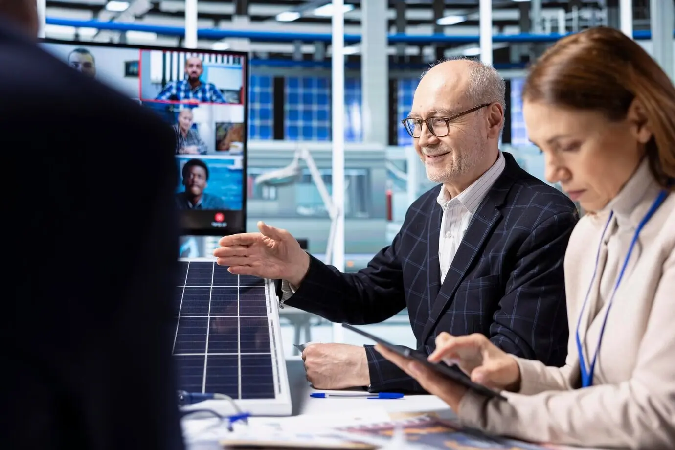 Инвесторы в офисе на заводе проводят финансовый анализ во время видеозвонка.